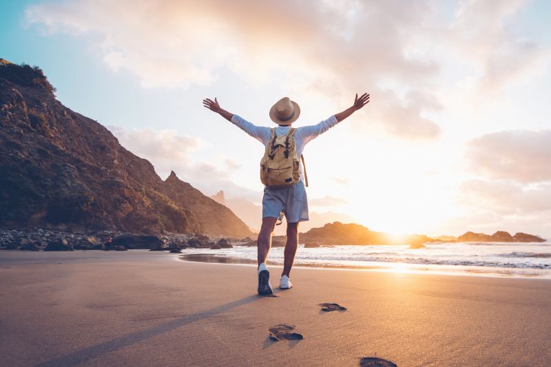 person standing on a beach with arms stretched open